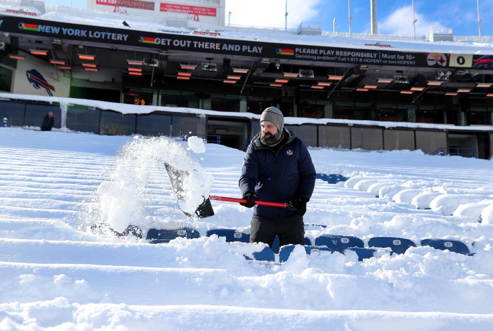 Joe Painter of Rochester, shovels snow from the lower bowl inside Highmark Stadium. Shovelers were instructed to only clear the steps and the walkways leaving the seating area for fans to handle themselves. Painter is staying for the game and came down to his shovel out his seats.