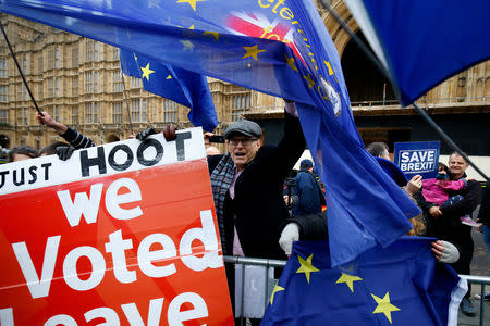 Pro and anti-Brexit demonstrators wave flags and placards outside the Houses of Parliament in London, Britain, December 10, 2018. REUTERS/Henry Nicholls