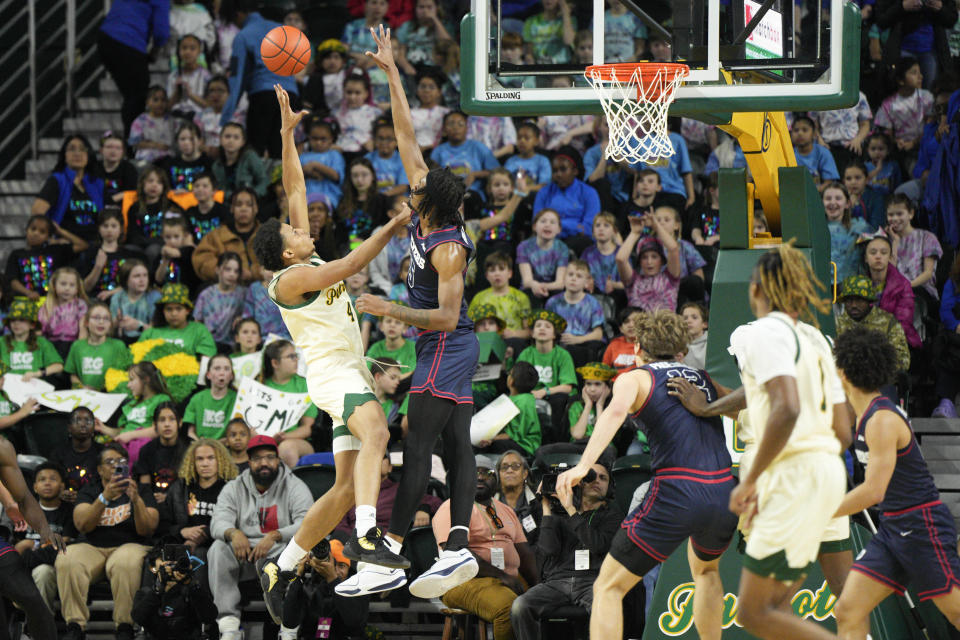 George Mason guard Keyshawn Hall (4) goes up against Dayton forward DaRon Holmes II (15) during the first half of an NCAA college basketball game, Wednesday, Feb. 21, 2024, in Fairfax, Va. (AP Photo/Jess Rapfogel)