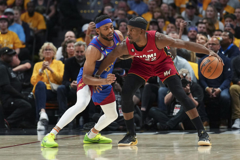 Miami Heat forward Jimmy Butler, right, is defended by Denver Nuggets forward Bruce Brown during the first half of Game 1 of basketball's NBA Finals, Thursday, June 1, 2023, in Denver. (AP Photo/Jack Dempsey)