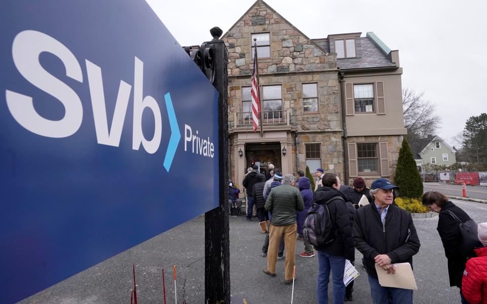 Customers and bystanders queue outside a Silicon Valley Bank branch on March 13, days after it was taken over by US regulators - AP Photo/Steven Senne