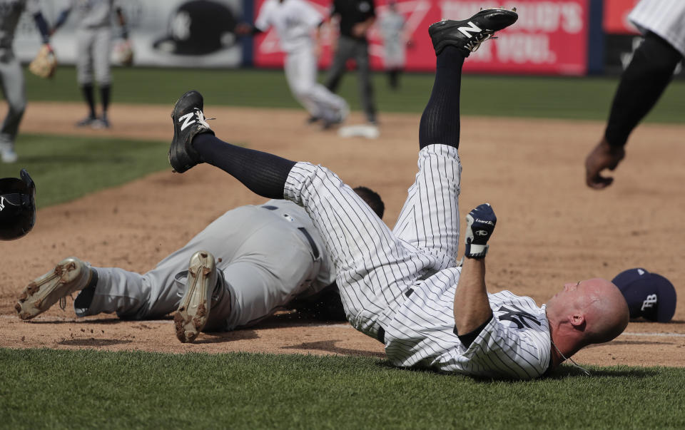 New York Yankees' Brett Gardner, right, falls to the ground after colliding with Tampa Bay Rays first baseman Rickie Weeks after Weeks reached for an errant throw by pitcher Xavier Cedeno during the sixth inning of a baseball game, Wednesday, April 12, 2017, in New York. Chase Headley scored on the play. Both Weeks and Gardner left the game. (AP Photo/Julie Jacobson)