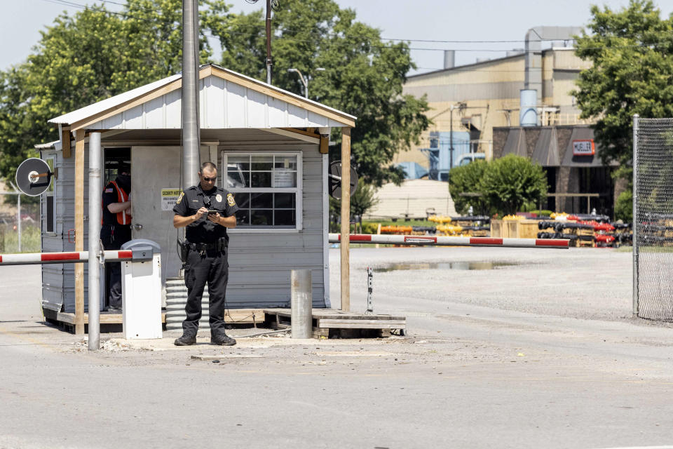 A police officer stands at the entrance to a Mueller Co. fire hydrant plant where police said multiple people were shot to death and others were wounded in Albertville, Ala., on Tuesday, June 15, 2021. (AP Photo/Vasha Hunt)