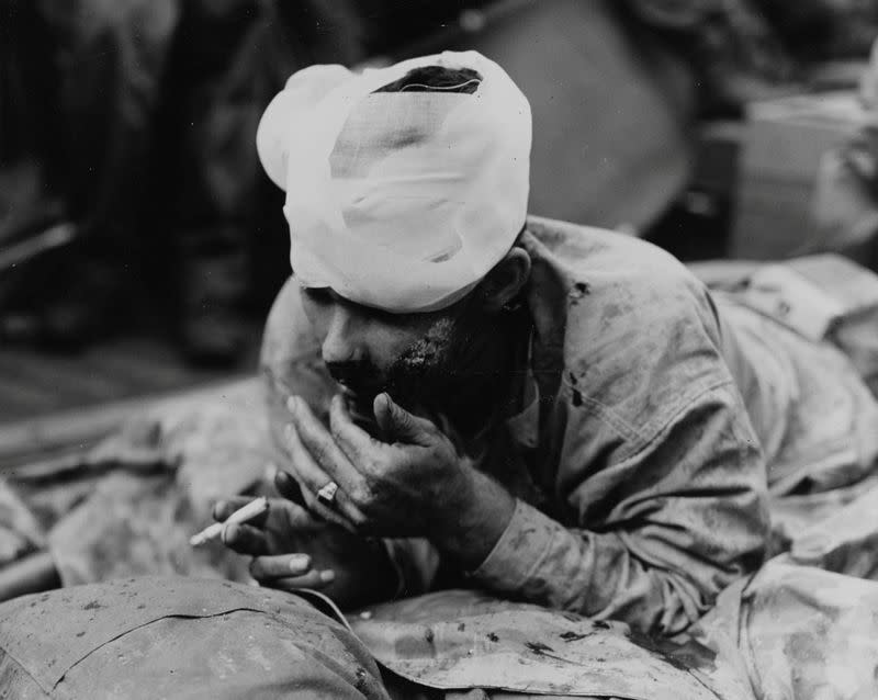 A U.S. Marine injured in the first wave assault at Iwo Jima rests