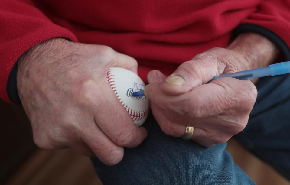 Former Major League Baseball pitcher Jack DiLauro signs a ball for a fan at his home in Malvern.