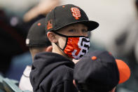 A young baseball fan wears a face mask while watching a spring baseball game between the San Francisco Giants and the Los Angeles Angels in Scottsdale, Ariz., Sunday, Feb. 28, 2021. (AP Photo/Jae C. Hong)