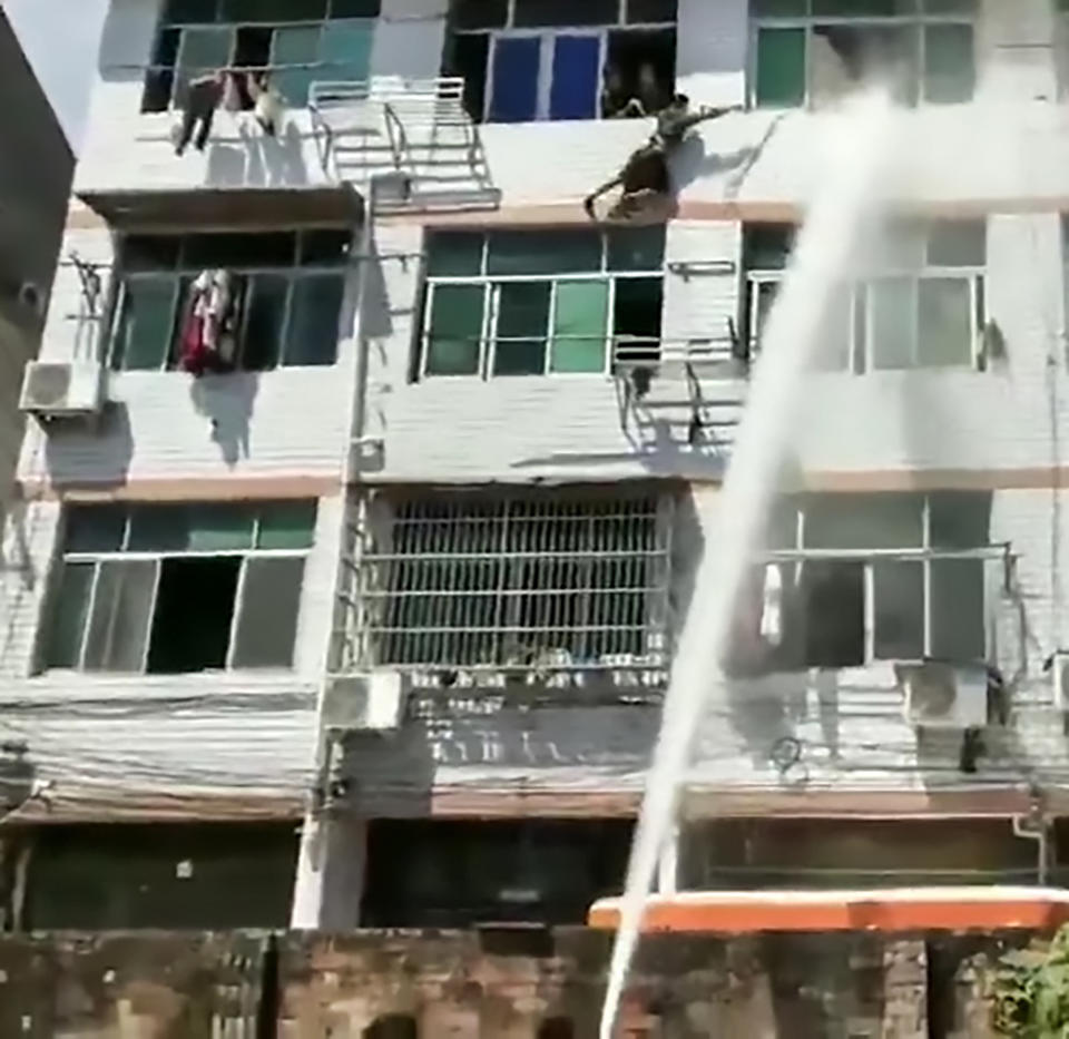 The woman being pushed away from the window with a water cannon (Asia Wire)