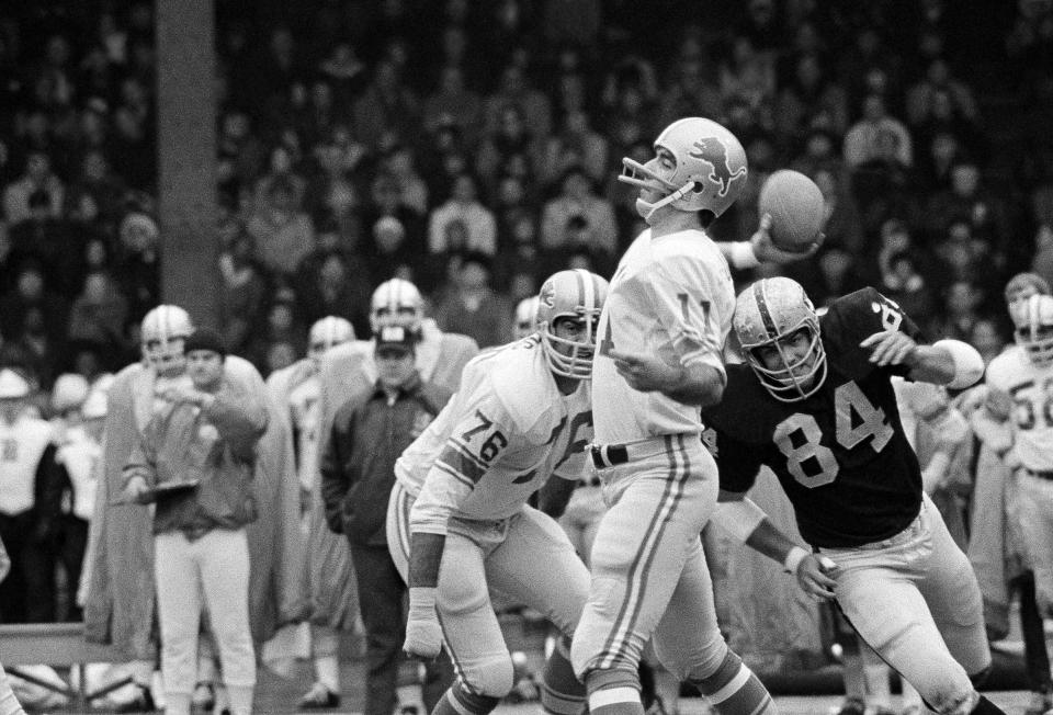 FILE - In this Nov. 26, 1970, file photo, Detroit Lions quarterback Greg Landry looks for Chuck Walton somewhere downfield during an NFL football game against the Oakland Raiders in Detroit. Landry become a solid starter and spot-starter for Detroit through 1978. He also played for Baltimore and Chicago, as well as two years in the USFL. (AP Photo/JMC, File)