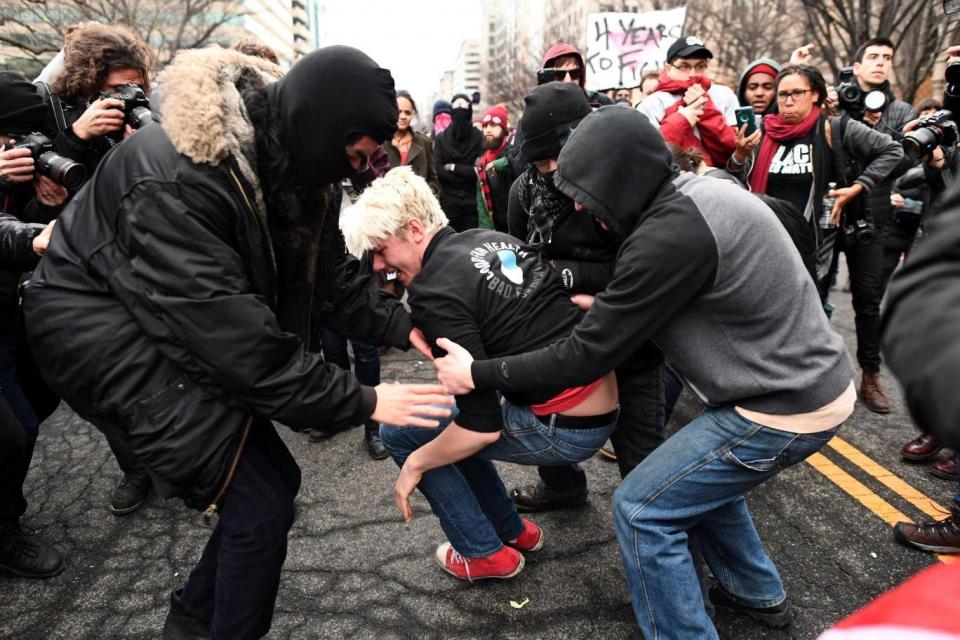 An anti-Trump protester screams after being hit by a paintball gun fired by Police during clashes in Washington, DC (JEWEL SAMAD/AFP/Getty Images)