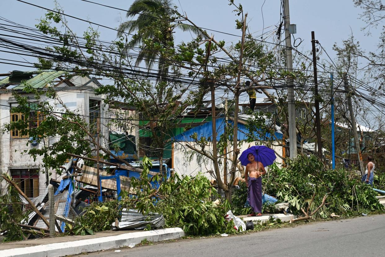 A man carrying an umbrella looks at the damage caused by Cyclone Mocha in Sittwe, Myanmar, on Monday.