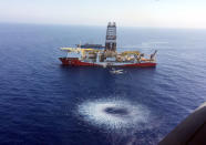 In this Tuesday, July 9, 2019 photo, a helicopter flies over Turkey's drilling ship, 'Fatih' dispatched towards the eastern Mediterranean, near Cyprus. Turkish officials say the drillships Fatih and Yavuz will drill for gas, which has prompted protests from Cyprus. (Turkish Defence Ministry via AP, Pool)