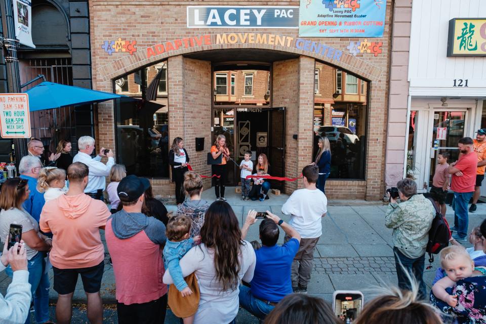 Lacey Herbert-Stephen cuts the ribbon during the recent grand opening of the Adaptive Movement Center in New Philadelphia.