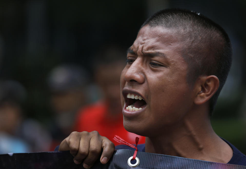 A demonstrator chants slogans calling for justice in the case of 43 missing students from the Isidro Burgos rural teachers college, as he joins a march by residents protesting the construction of a new airport, in Mexico City, Thursday, Aug. 23, 2018. Demonstrators marched to protest a $15.7-billion airport project that threatens a decades-old effort to restore lakes that originally covered the valley. (AP Photo/Marco Ugarte)