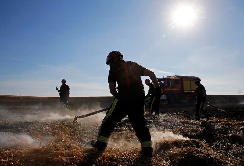 French firefighters extinguish a burning wheat field in Beauvois-en-Cambresis