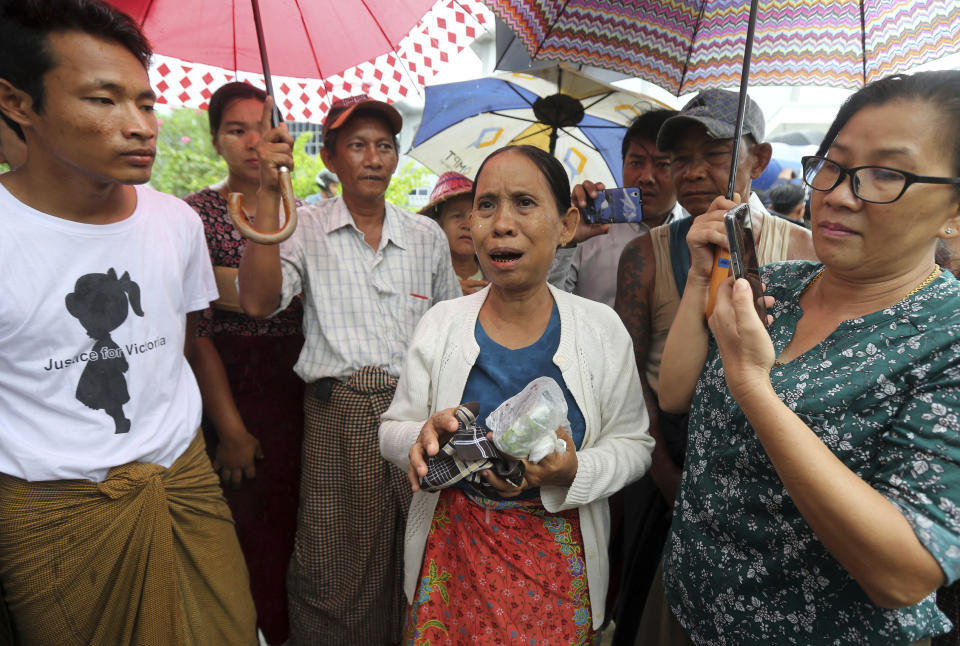 Daw Yee, center, mother of rape suspect Aung Kyaw Myo, talks to journalists after the trial of her son at a court Wednesday, July 24, 2019, in Nyapyitaw, Myanmar. A Myanmar court held another hearing related to the rape of a 2-year old girl at her nursery school, in a case that generated huge interest and protests. (AP Photo/Aung Shine Oo)