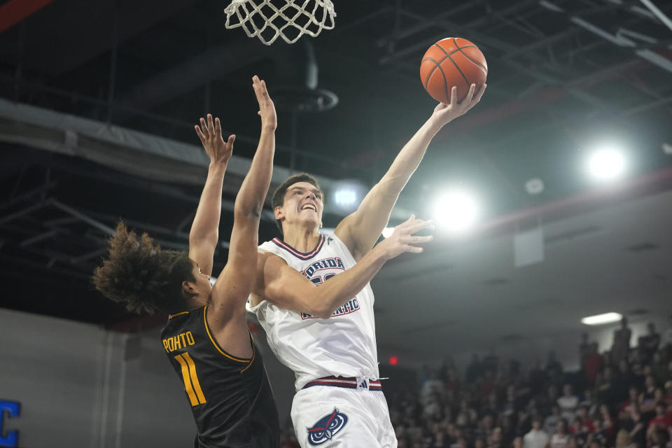 Florida Atlantic center Vladislav Goldin (50) drives to the basket as Wichita State forward Kenny Pohto (11) defends during the first half of an NCAA college basketball game, Thursday, Jan. 18, 2024, in Boca Raton, Fla. (AP Photo/Marta Lavandier)