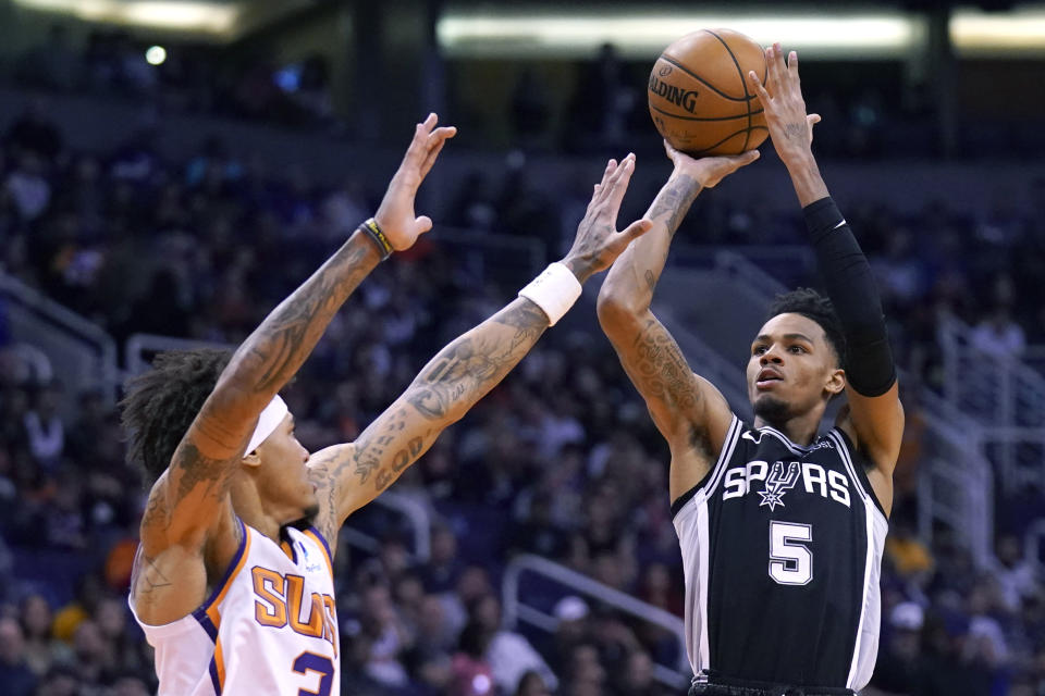San Antonio Spurs guard Dejounte Murray (5) shoots over Phoenix Suns forward Kelly Oubre Jr. during the first half of an NBA basketball game Monday, Jan. 20, 2020, in Phoenix. (AP Photo/Rick Scuteri)