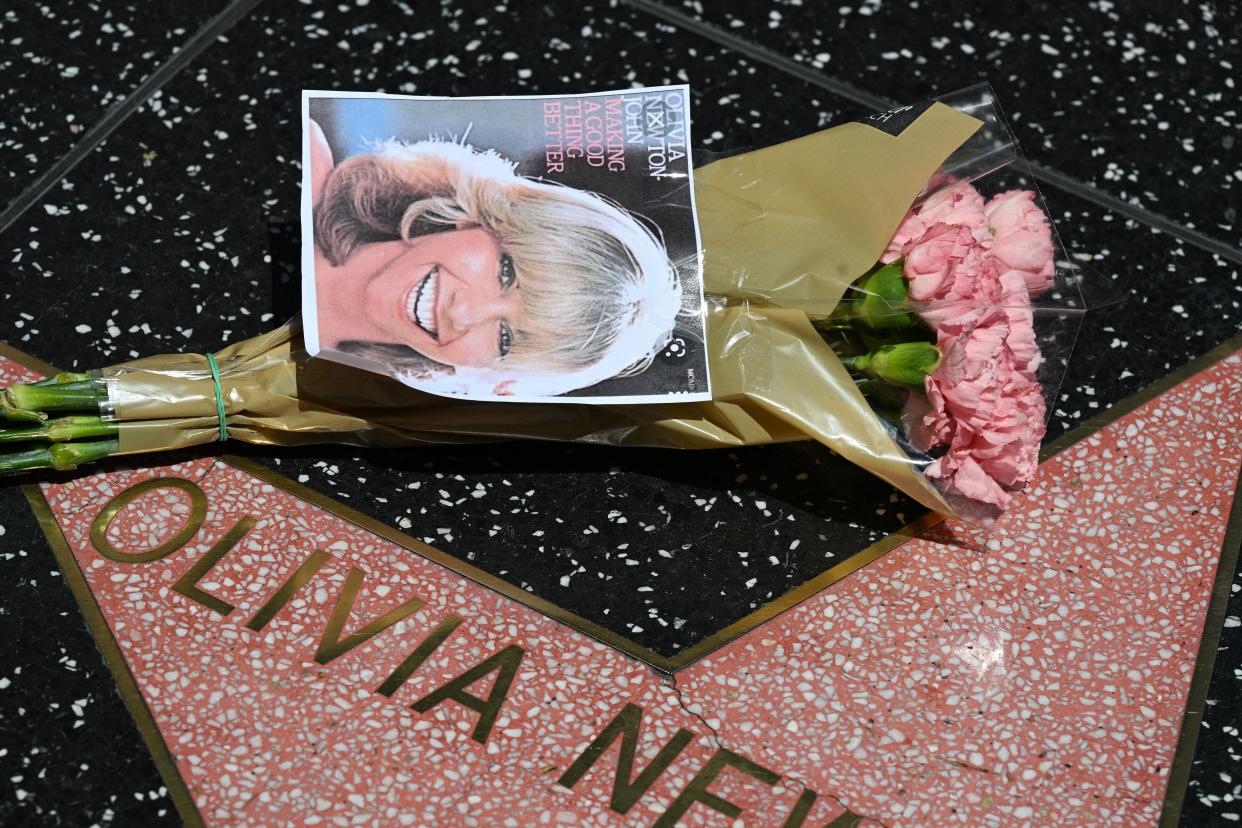 Flowers and a photo placed on the star of Australian singer and actress Olivia Newton-John on the Hollywood Walk of Fame in Hollywood, Calif.