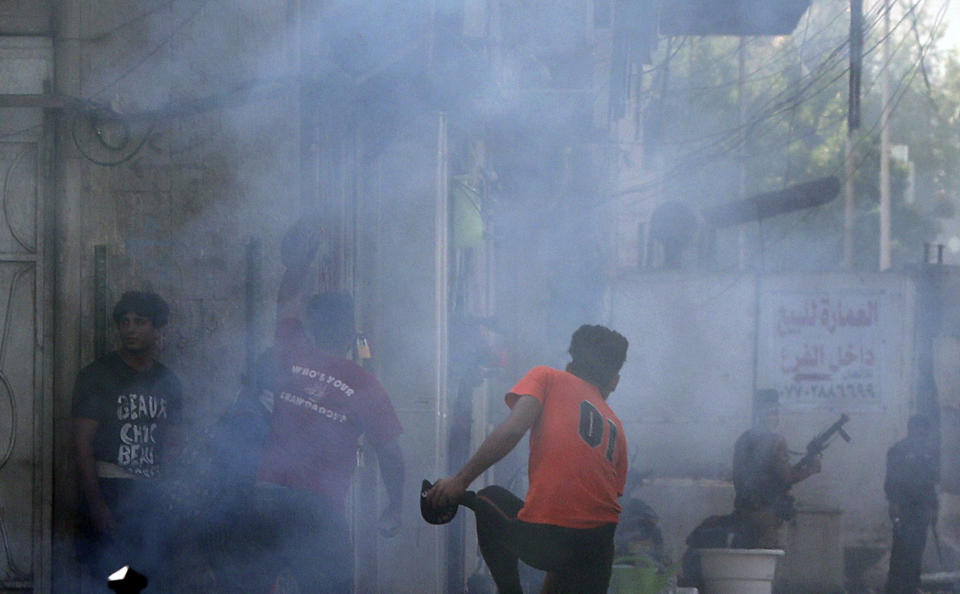 Iraqi riot police fire tear gas to disperse anti-government protesters during ongoing protests in central Baghdad, Iraq, Saturday, Nov. 9, 2019. (AP Photo/Hadi Mizban)