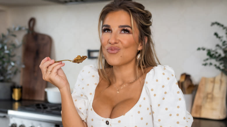 Jessie James Decker with spoonful of food in kitchen