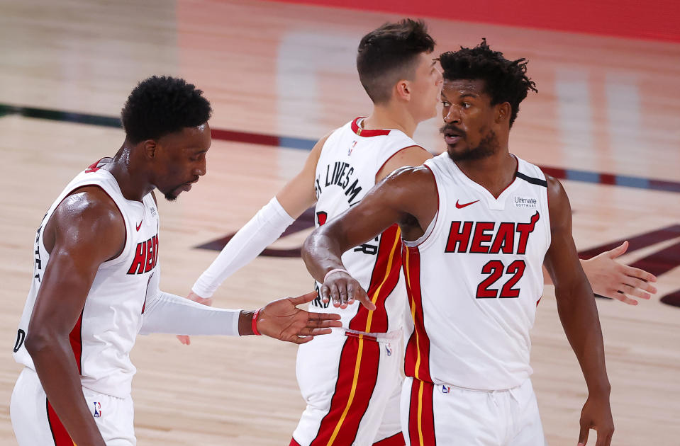 Jimmy Butler slaps hands on the court with teammates. 