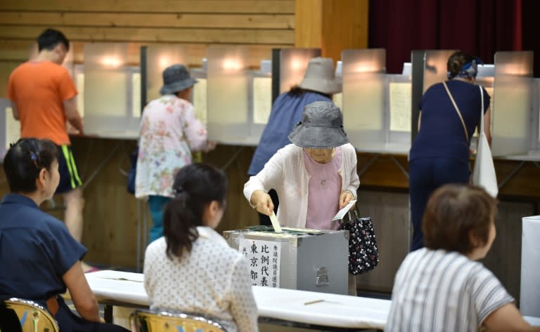 Voters cast their ballots at a polling station in Tokyo