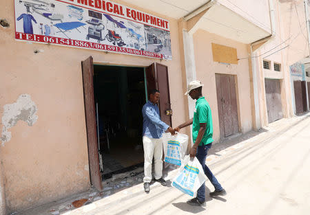 A customer receives items that he bought via the Somali Online Marker (SOOMAR) in Mogadishu, Somalia, October 17, 2018 REUTERS/Feisal Omar