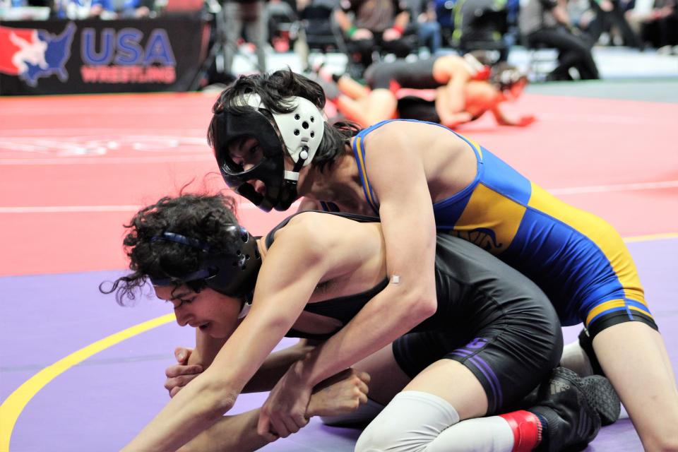Miguel Franco of Dolores Huerta Prep gains top control over Aiden Trujillo from John Mall in the CHSAA Class 2A state tournament first round held at Ball Arena on Feb. 16, 2023.