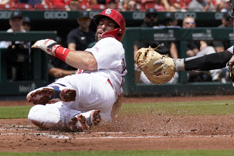 St. Louis Cardinals' Paul Goldschmidt scores past the outstretched arm of Miami Marlins catcher Jacob Stallings during the first inning of a baseball game Wednesday, July 19, 2023, in St. Louis. (AP Photo/Jeff Roberson)