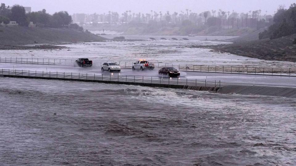 PHOTO: Vehicles cross over a flood control basin that has almost reached the street, Sunday, Aug. 20, 2023, in Palm Desert, Calif. (Mark J. Terrill/AP)