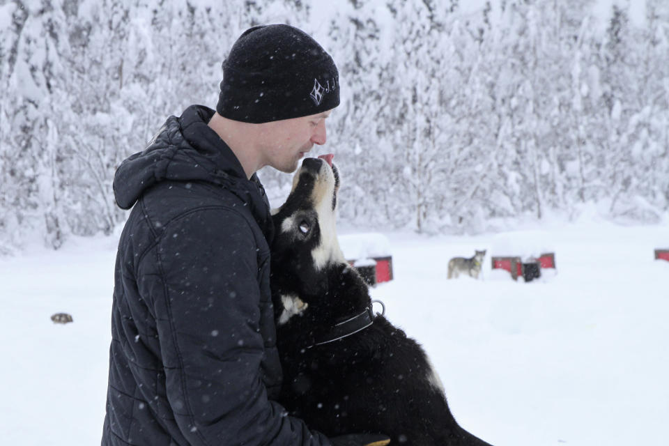 Five-time Iditarod champion Dallas Seavey is shown Feb. 22, 2022, playing with Ace, one of his dogs at his kennel in Talkeetna, Alaska. Seavey is tied with musher Rick Swenson for the most Iditarod victories ever, and Seavey is looking for his sixth title when the Iditarod Trail Sled Dog Race starts Saturday, March 5, in Alaska. (AP Photo/Mark Thiessen)