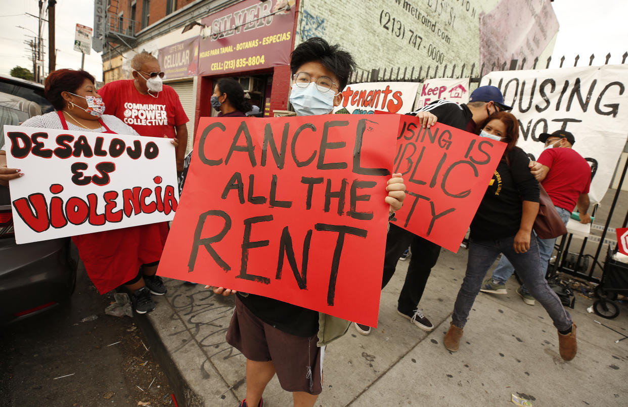 Protesters in masks carry red posters saying: Cancel All the Rent and Desalojo es Violencia (Eviction is Violence).                                                           Kris at center joins housing advocates and tenants gathered  against eviction of tenants from the 50 unit Tokio Hotel apartments located at 1013Â½ S Central Ave in downtown Los Angeles Monday morning. A coalition of organizations were present to prevent a possible Sheriffs team that would enforce the evictions. The group says two of the families would face certain houselessness should the eviction be carried out. In one case despite having filled out their Emergency Rental Assistance Program (ERAP) forms within the September 30 deadline, Maria Martinez and Jose Silva both received a Sheriff's notice to vacate their longtime homes.  Martinez and Silva are among those most vulnerable populations most deeply impacted by the COVID-19 pandemic. Martinez, a former street vendor, has been hospitalized several times throughout the pandemic, requires dialysis treatments and can no longer work, thus causing financial hardship for her and her family. The family contends they suffer from continuous harassment from the landlord, including retention of mail and important notices.  Tokio Hotel on Monday, Oct. 4, 2021 in Los Angeles, CA. (Al Seib / Los Angeles Times via Getty Images).