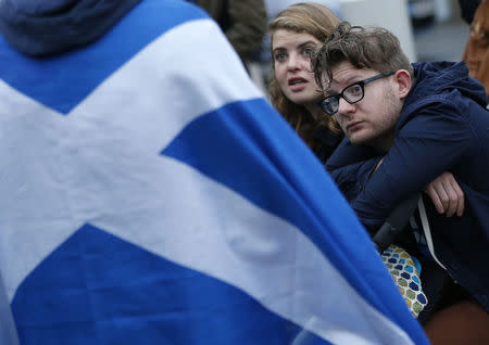 A couple sit outside the Scottish Parliment after the referendum on Scottish independence in Edinburgh, Scotland September 19, 2014. REUTERS/Russell Cheyne