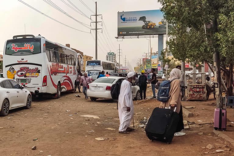 Varias personas se preparan para subir a un autobús que sale de Jartum, en el sur de la capital sudanesa, el 24 de abril de 2023, mientras en la ciudad se libran batallas entre el ejército y los paramilitares.