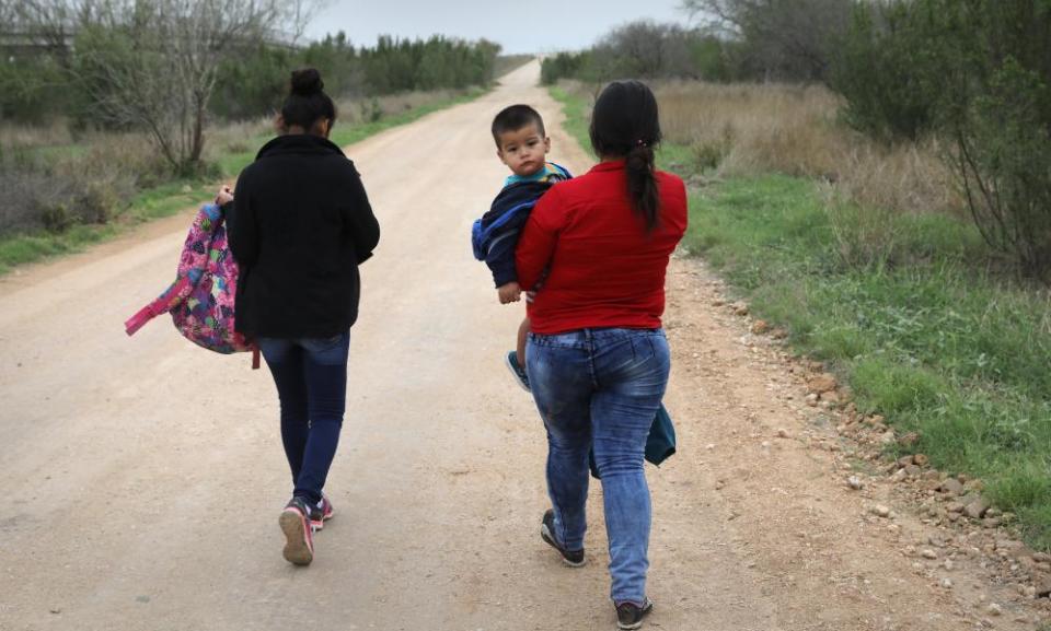 Central American migrants walk after crossing the US-Mexico border to turn themselves into border patrol agents near McAllen, Texas.