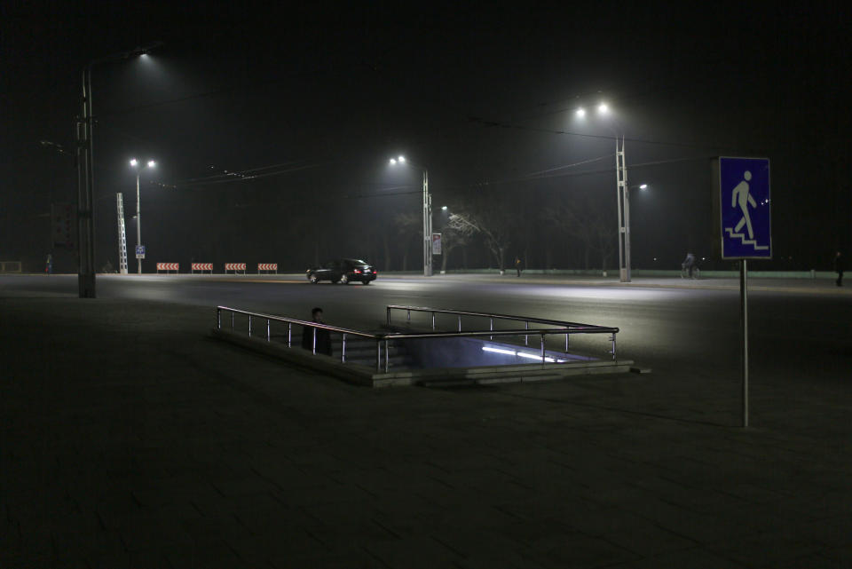 In this Tuesday Feb. 25, 2014 photo, a North Korean man walks down to a pedestrian tunnel at a residential complex which is lit at night in Pyongyang, North Korea. (AP Photo/Vincent Yu)