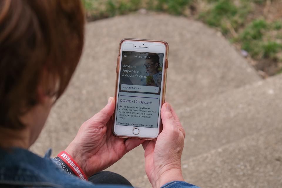 Holly Specht pulls up the application on her phone that she uses for telemedicine doctor visits from her home in Fort Thomas, Kentucky, on Tuesday, March 24, 2020.