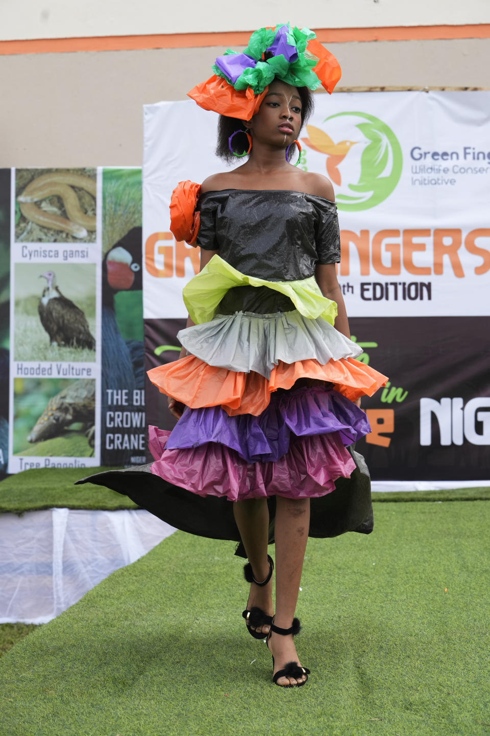 Rose Musa, wearing an outfit made from recycled plastic bags, walk on the runway during a 'trashion show' in Sangotedo Lagos, Nigeria, Saturday, Nov. 19, 2022. (AP Photo/Sunday Alamba)