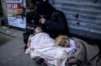 A Syrian refugee woman begs with her children on the street in the Beyoglu district of Istanbul on April 17, 2015