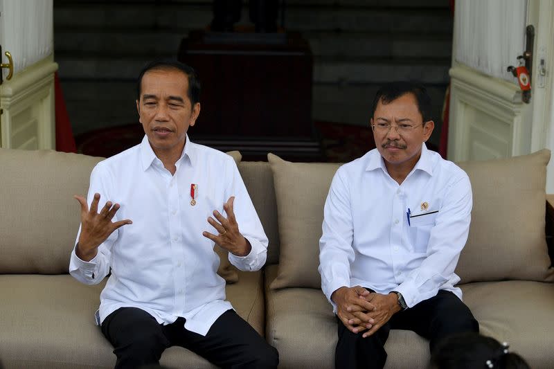 Indonesian President Joko Widodo talks as Indonesia's Health Minister Terawan Agus Putranto sits next to him during a news conference at Presidential Palace in Jakarta