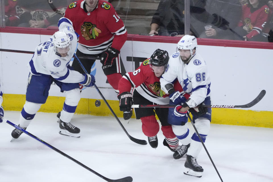 Chicago Blackhawks' Jake McCabe (6) and Tampa Bay Lightning's Nikita Kucherov (86) keep their eyes on the airborne puck during the first period of an NHL hockey game Tuesday, Jan. 3, 2023, in Chicago. (AP Photo/Charles Rex Arbogast)