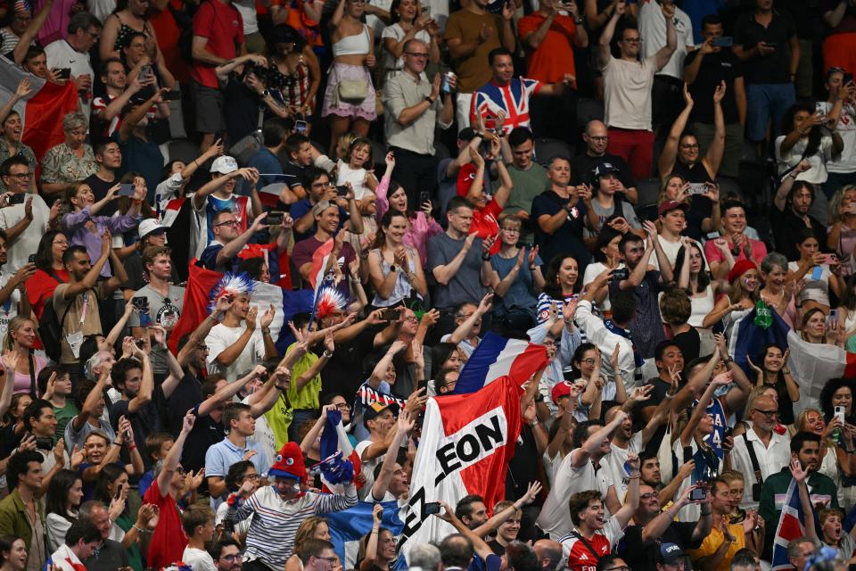 Supporters cheer as gold medallist France's Leon Marchand (unseen) is called to the podium of the men's 200m individual medley swimming event during the Paris 2024 Olympic Games at the Paris La Defense Arena in Nanterre, west of Paris, on August 2, 2024. (Photo by Oli SCARFF / AFP) (Photo by OLI SCARFF/AFP via Getty Images)