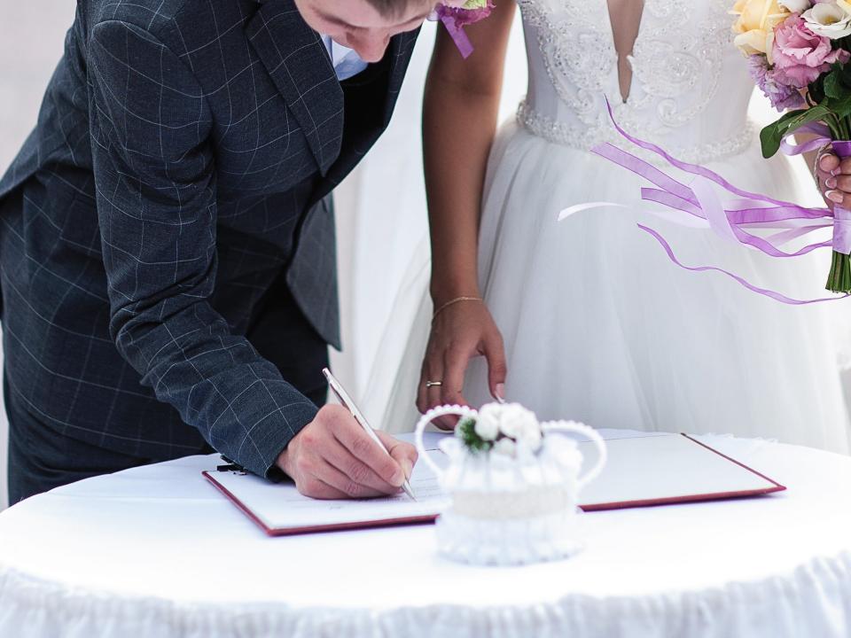 Groom signs marriage license