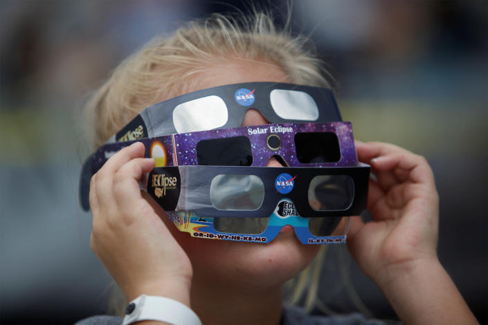 <p>Ariana Mareyev (10) of Charleston wears several pairs of solar glasses on the flight deck of the Naval museum ship U.S.S. Yorktown during the Great American Eclipse in Mount Pleasant, South Carolina, Aug. 21, 2017. (Photo: Randall Hill/Reuters) </p>