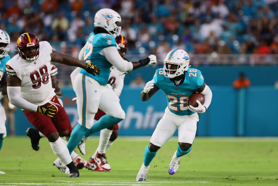 Aug 17, 2024; Miami Gardens, Florida, USA; Miami Dolphins running back De'Von Achane (28) runs with the football against the Washington Commanders during the second quarter of a preseason game at Hard Rock Stadium. Mandatory Credit: Sam Navarro-USA TODAY Sports