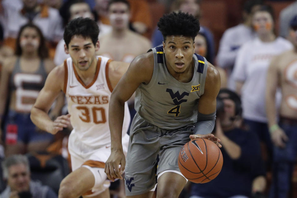 West Virginia guard Miles McBride (4) drives the pass past Texas forward Brock Cunningham (30) during the first half of an NCAA college basketball game, Monday, Feb. 24, 2020, in Austin, Texas. (AP Photo/Eric Gay)