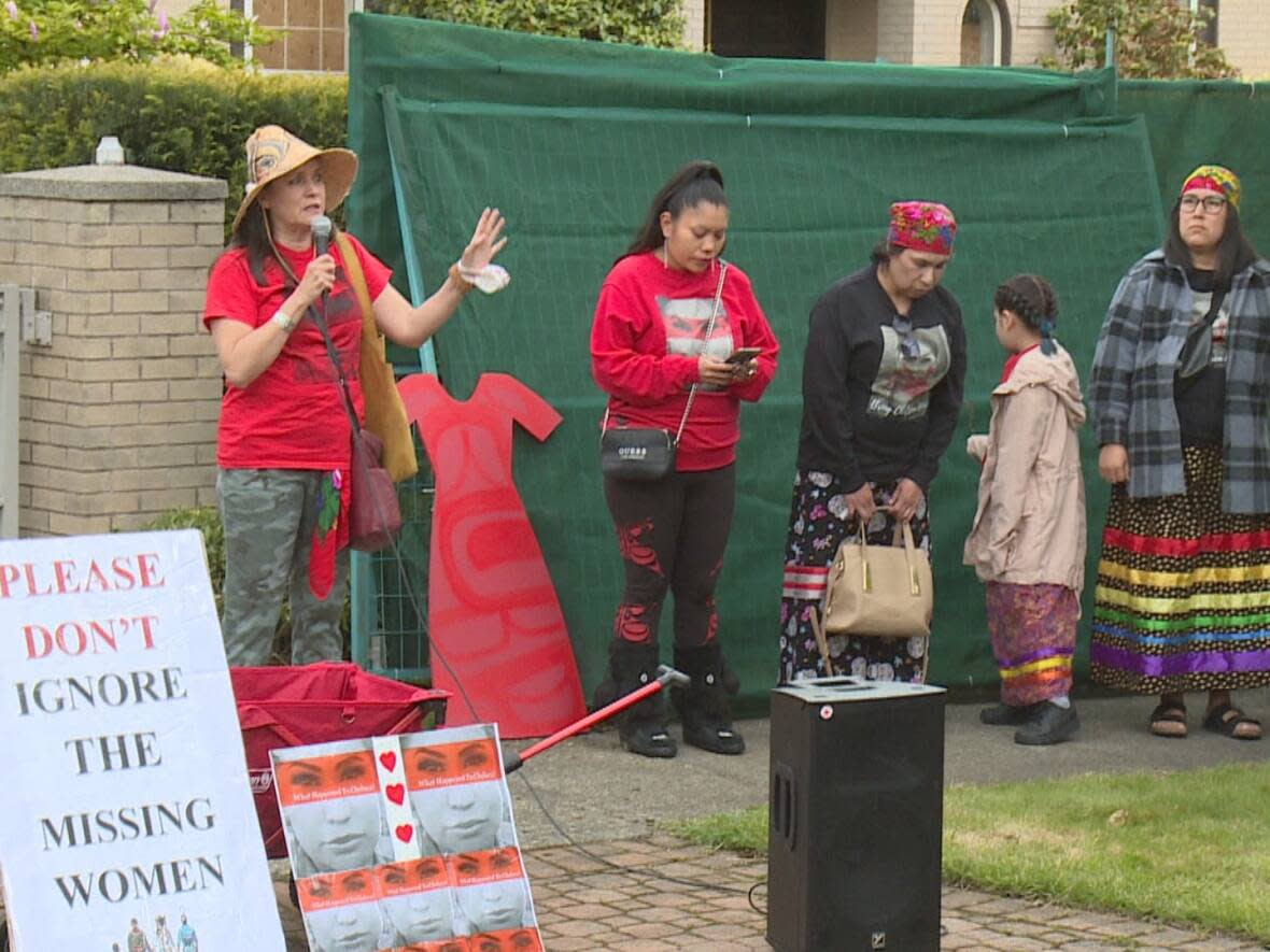 Sheila Poorman, third from left, bows her head at a vigil held on Saturday, May 28, 2022 at the Vancouver residence where her daughter's remains were found on April 22, a year and a half after she went missing. (Janella Hamilton/CBC News - image credit)