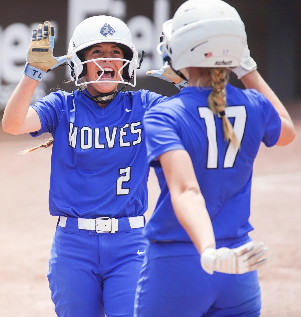 Waukee Northwest's Bailie Kroll (2) and Reagan Bartholomew (17) celebrate runs scored against Muscatine during the Class 5A semifinals at Harlan Rogers Sports Complex on Wednesday in Fort Dodge.