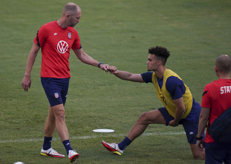 United States' head coach Gregg Berhalter, left, greets Antonee Robinson during a training session ahead of the World Cup 2022 qualifying soccer match against Jamaica in Kingston, Monday, Nov. 15, 2021.(AP Photo/Fernando Llano)