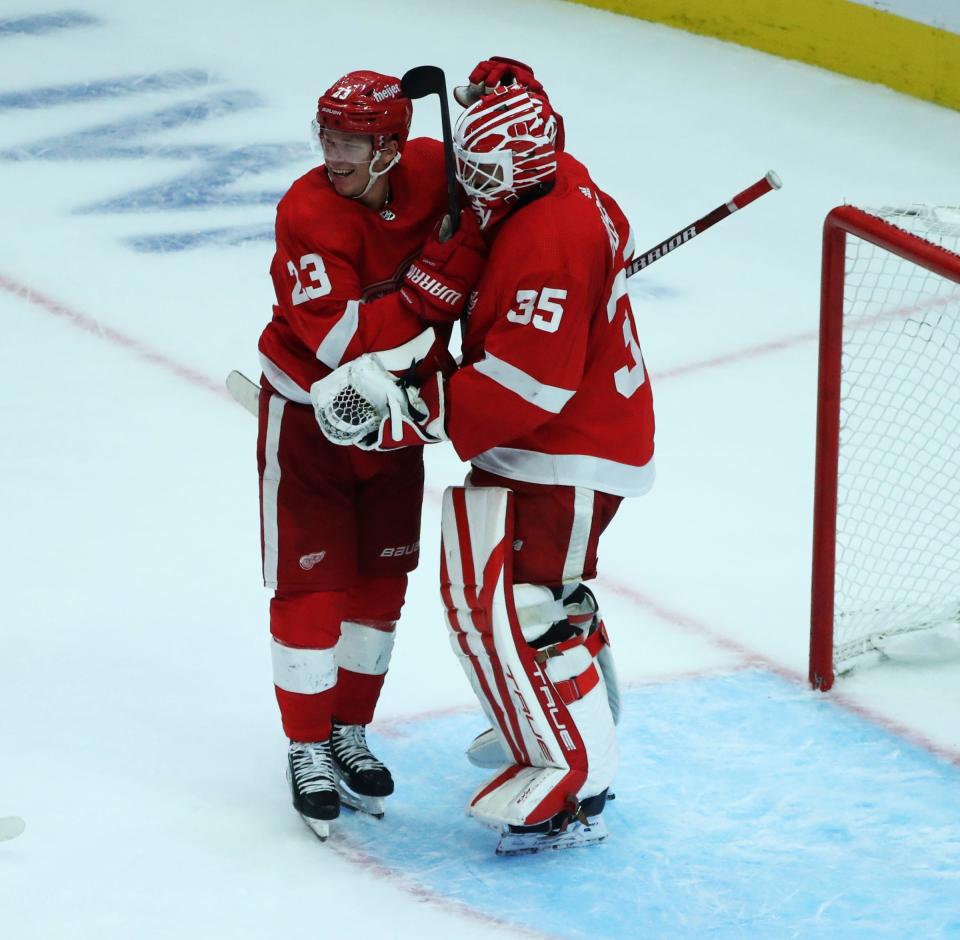 Red Wings left wing Lucas Raymond and goaltender Ville Husso celebrate after the Wings' 6-4 win over the Lightning on Saturday, Oct. 14 2023, at Little Caesars Arena.
